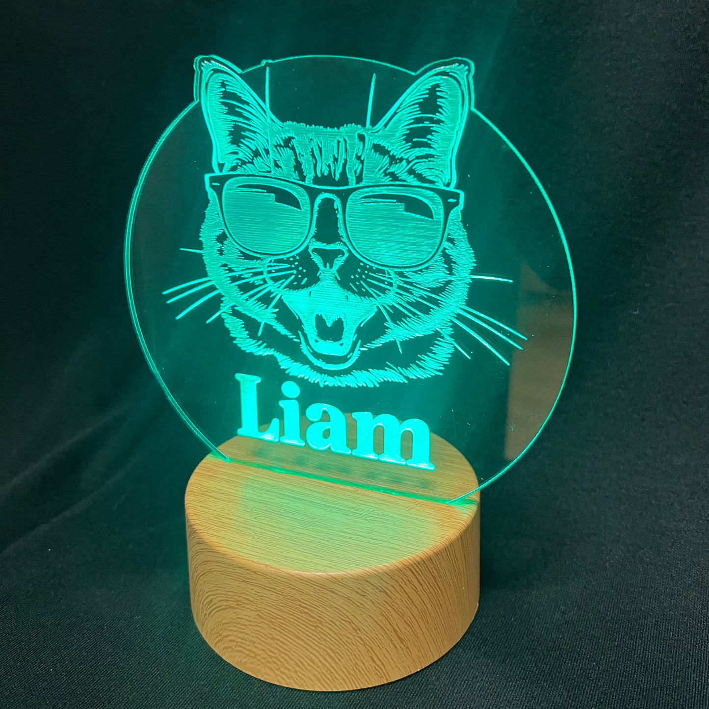 Cool Cat Night Light featuring a laser-engraved acrylic design of a cat wearing sunglasses, illuminated on a warm white LED base, with a personalized name beneath the cat