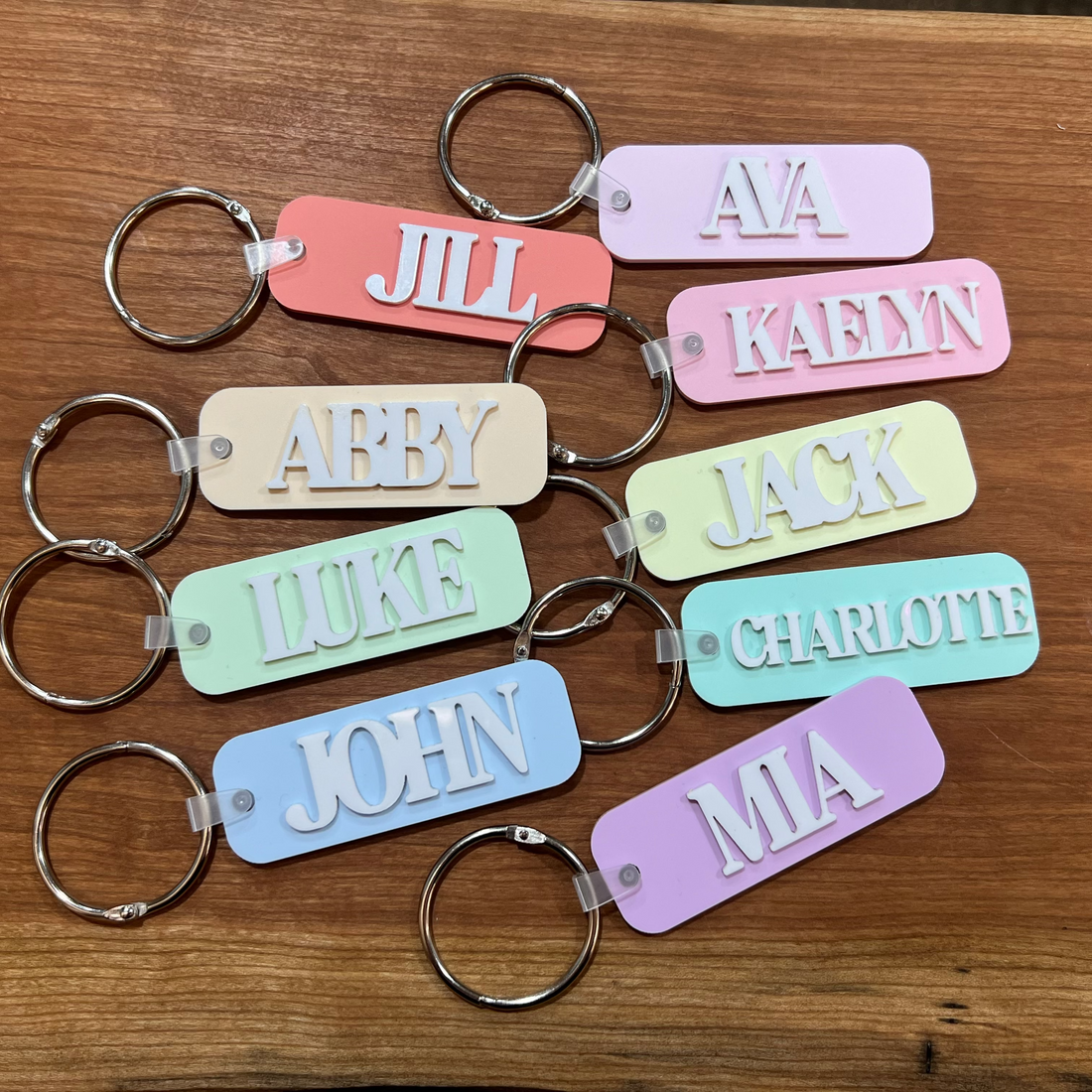 Several personalized bag tags in various pastel colors