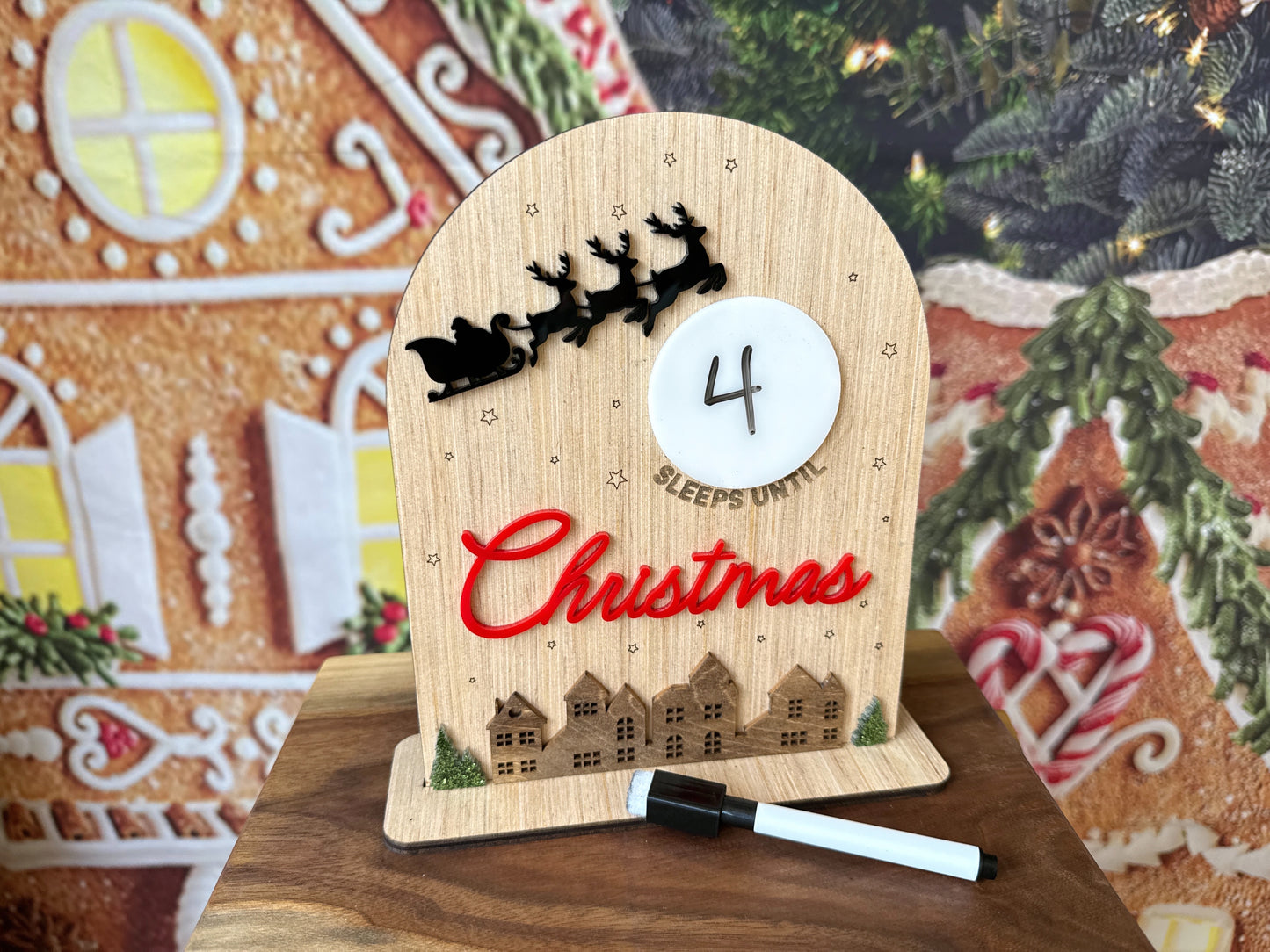 Small wooden sign with a dry erase moon that says (blank) sleeps until Christmas with Santa's sleigh and a holiday village 