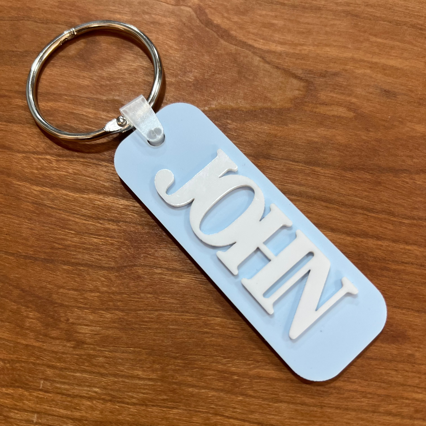Light blue bag tag with the name John on it