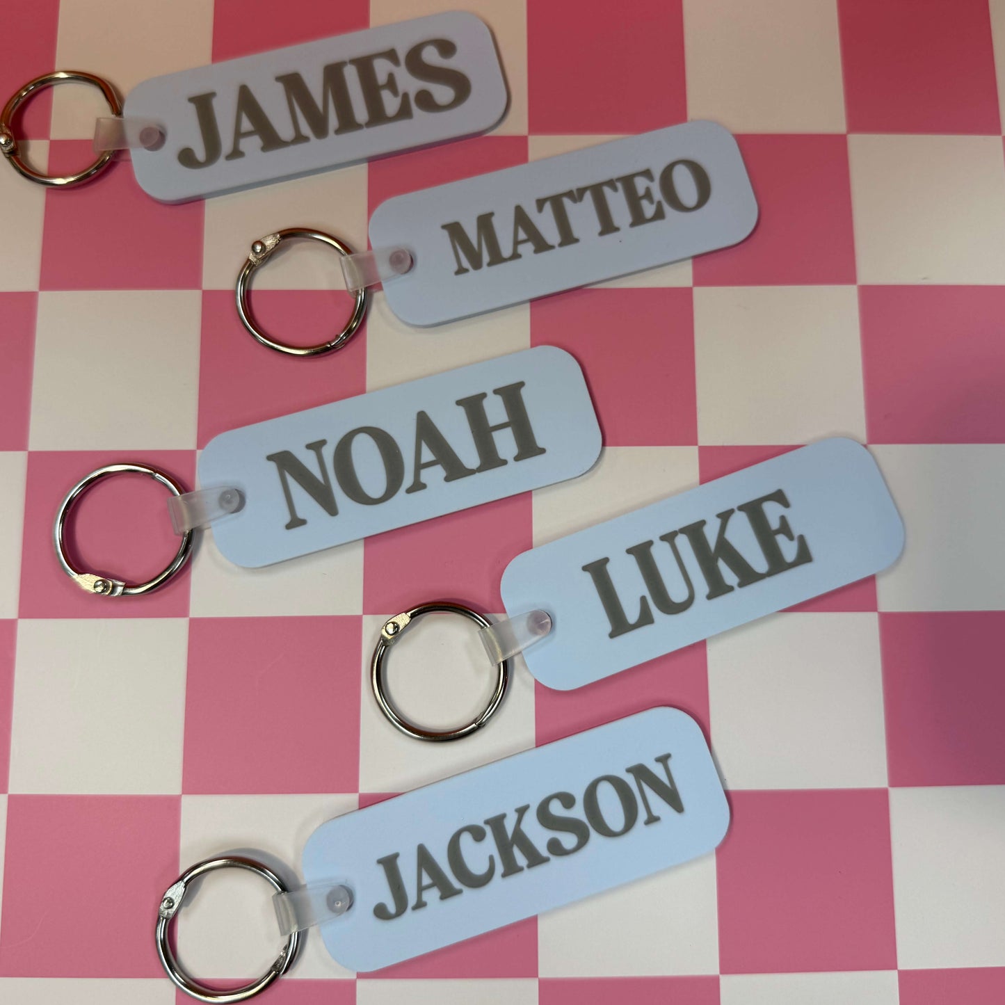 Set of personalized keychains with names on a checkered background