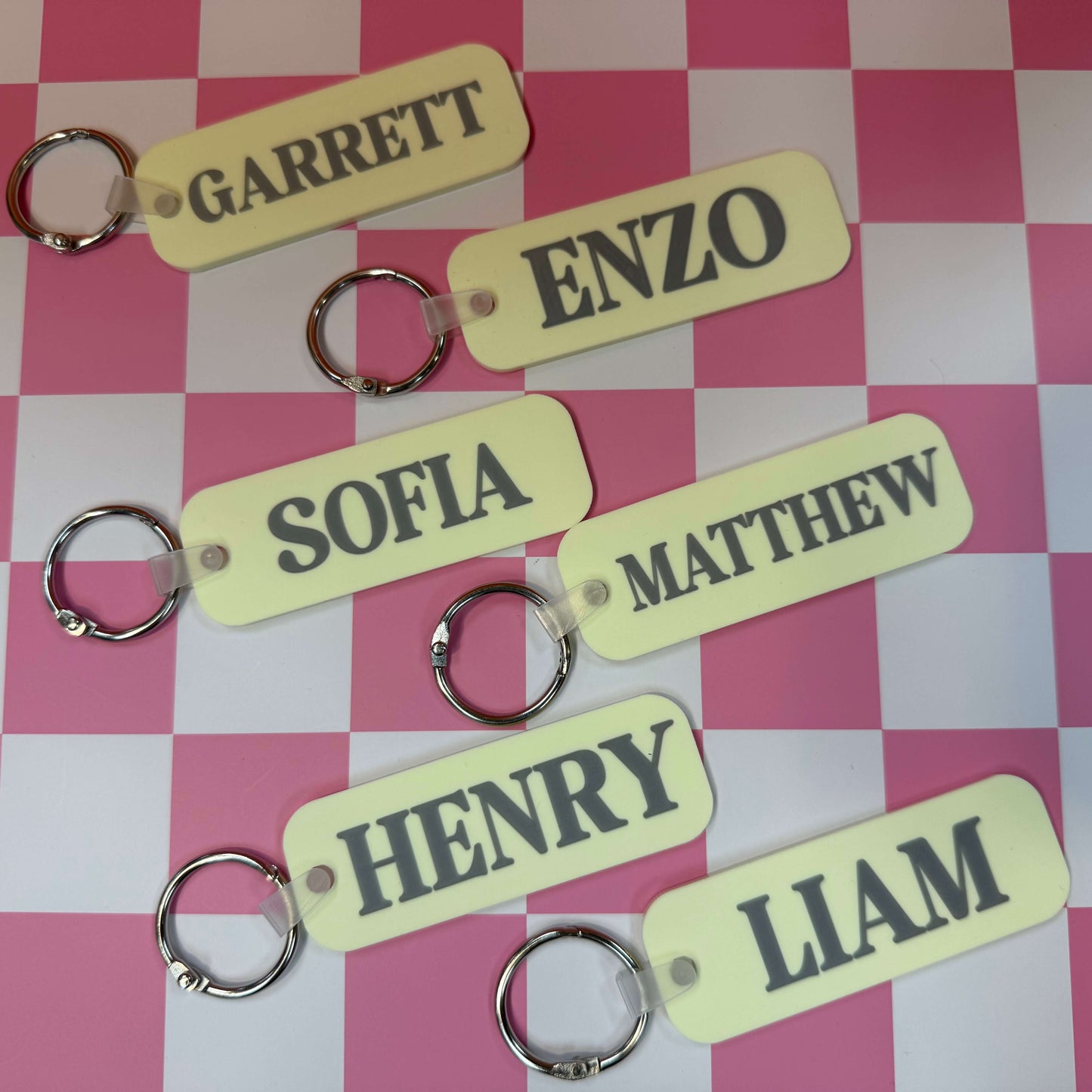 light yellow bag tags with various names on a checkered background
