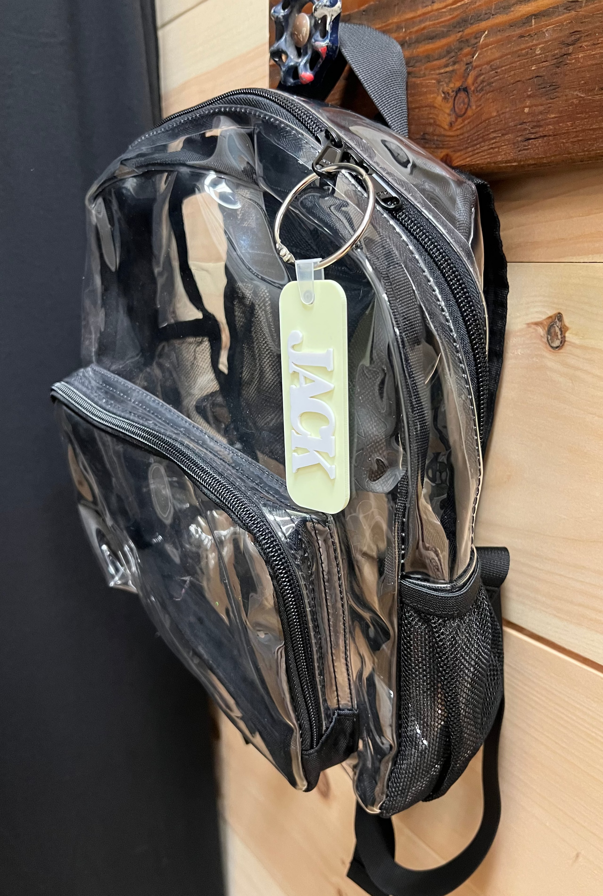Clear backpack with a visible brand tag on a wooden surface