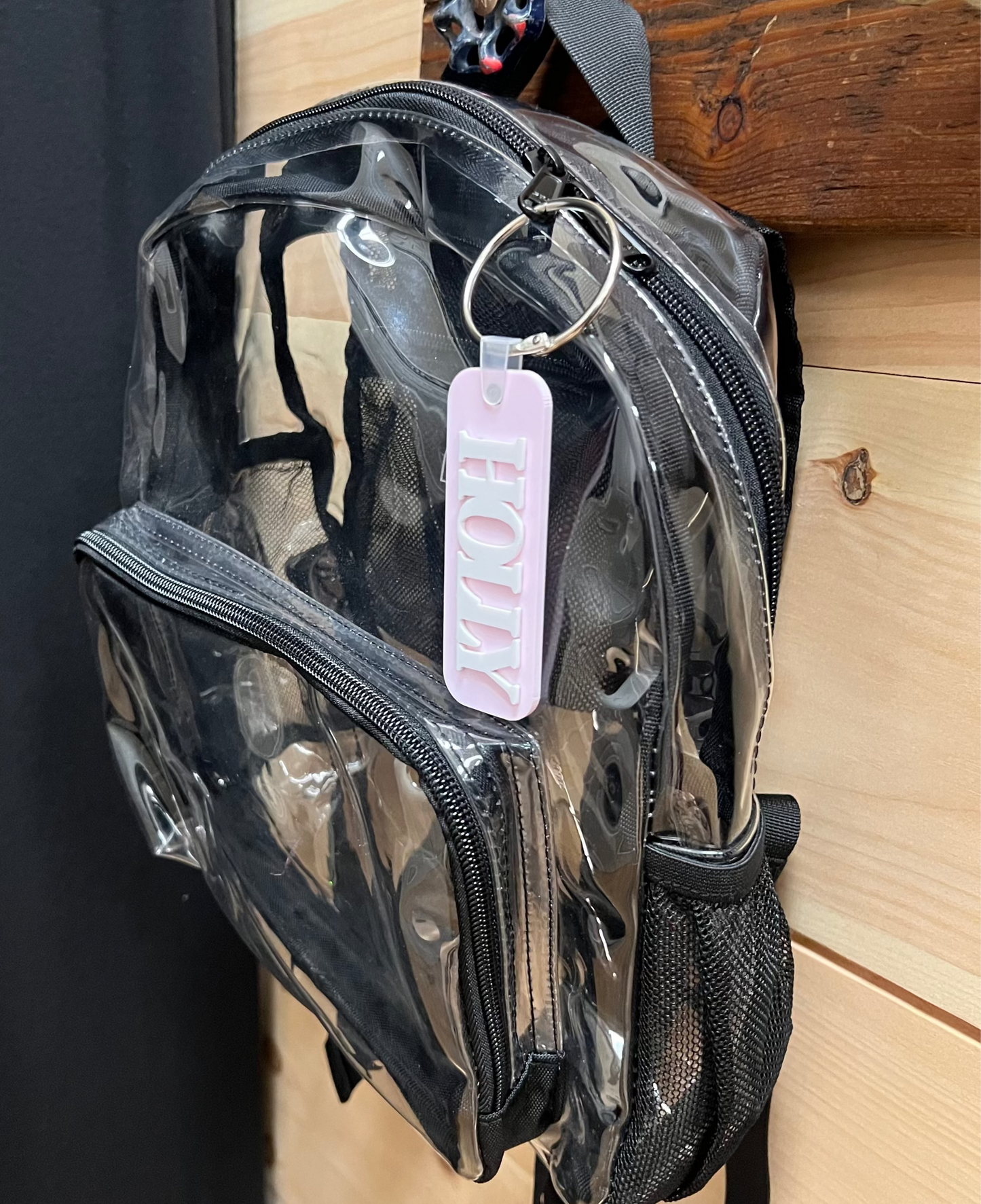 Small backpack with a blush pink bag tag with the name Holly on it