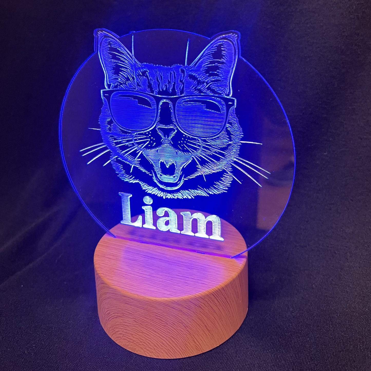 Cool Cat Night Light featuring a laser-engraved acrylic design of a cat wearing sunglasses, illuminated on a warm white LED base, with a personalized name beneath the cat