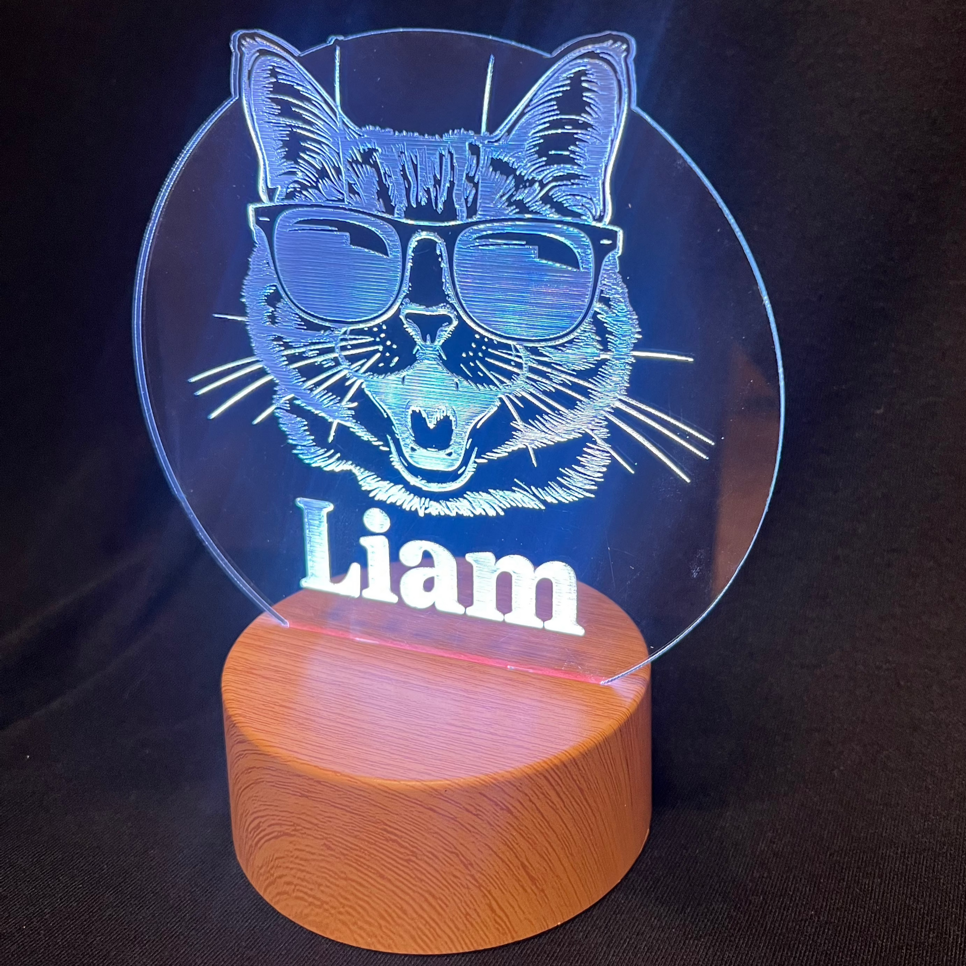 Cool Cat Night Light featuring a laser-engraved acrylic design of a cat wearing sunglasses, illuminated on a warm white LED base, with a personalized name beneath the cat