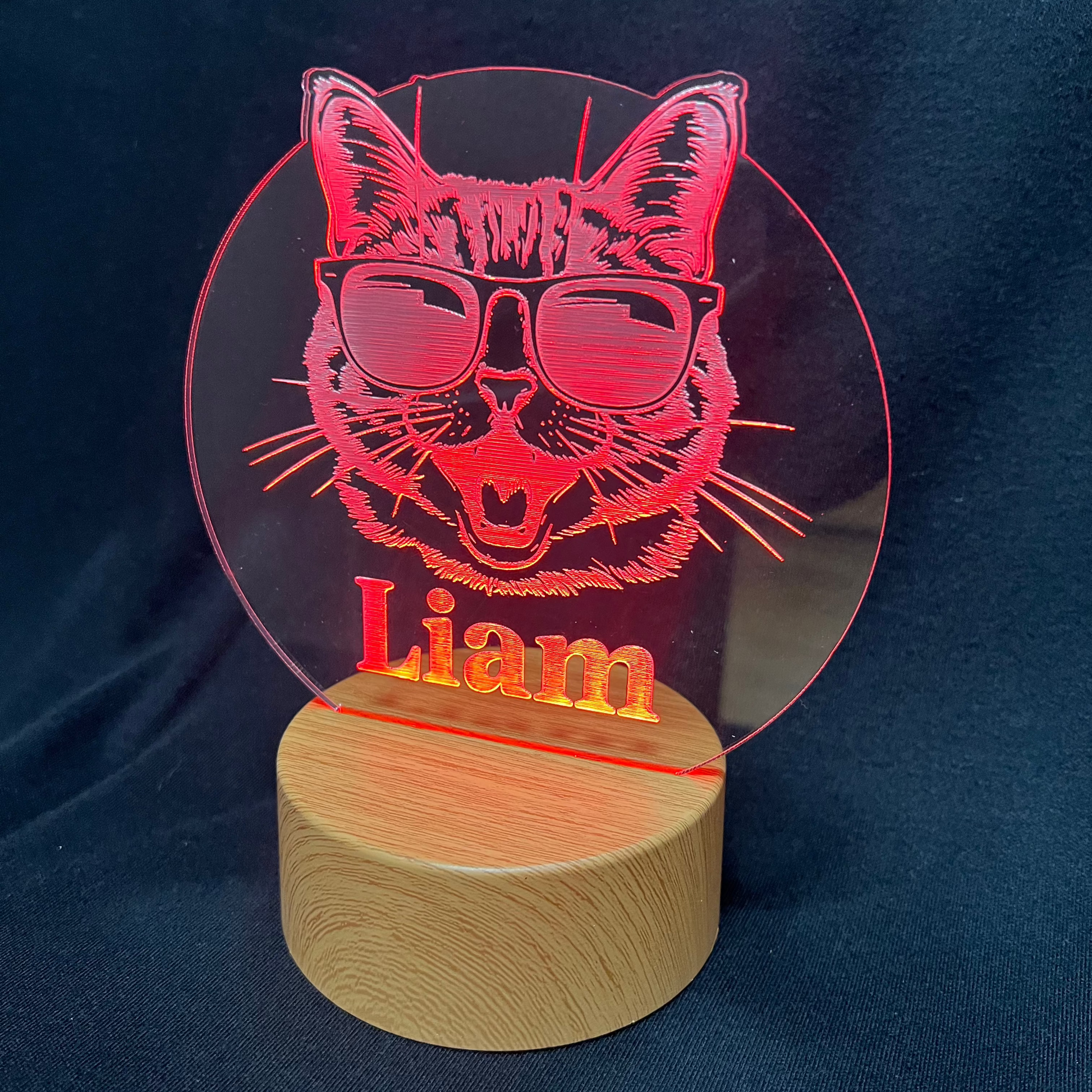 Cool Cat Night Light featuring a laser-engraved acrylic design of a cat wearing sunglasses, illuminated on a warm white LED base, with a personalized name beneath the cat