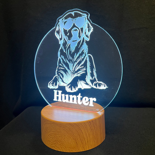 Personalized dog nightlight featuring a cool dog wearing sunglasses, with a custom name engraved below, glowing softly in a warm LED light.