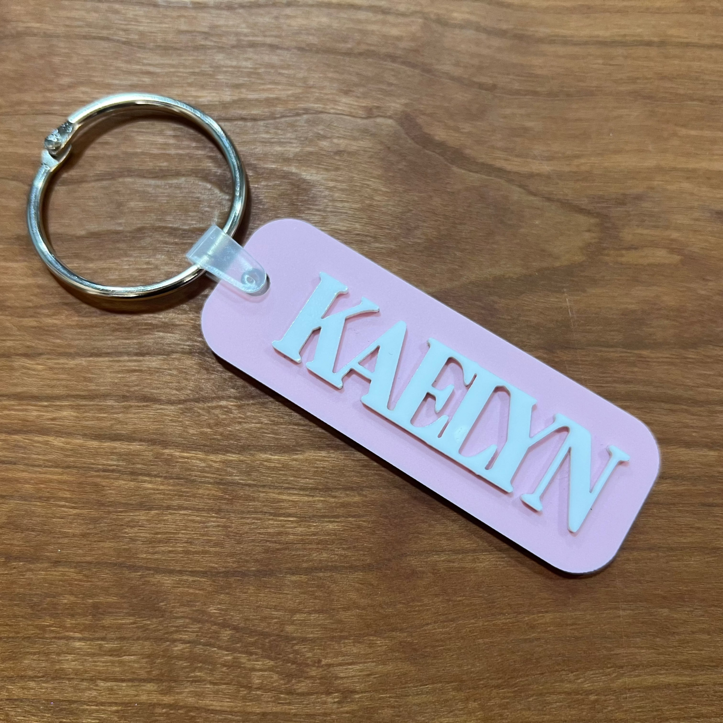 Light pink dusty rose colored bag tag with the name Kaelyn on it