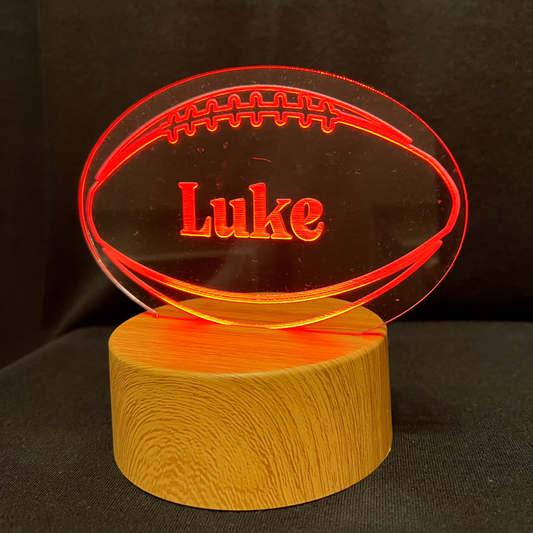 Football Name Night Light – Personalized LED night light featuring an engraved football design with a custom name in the center, glowing warmly for football players and fans.