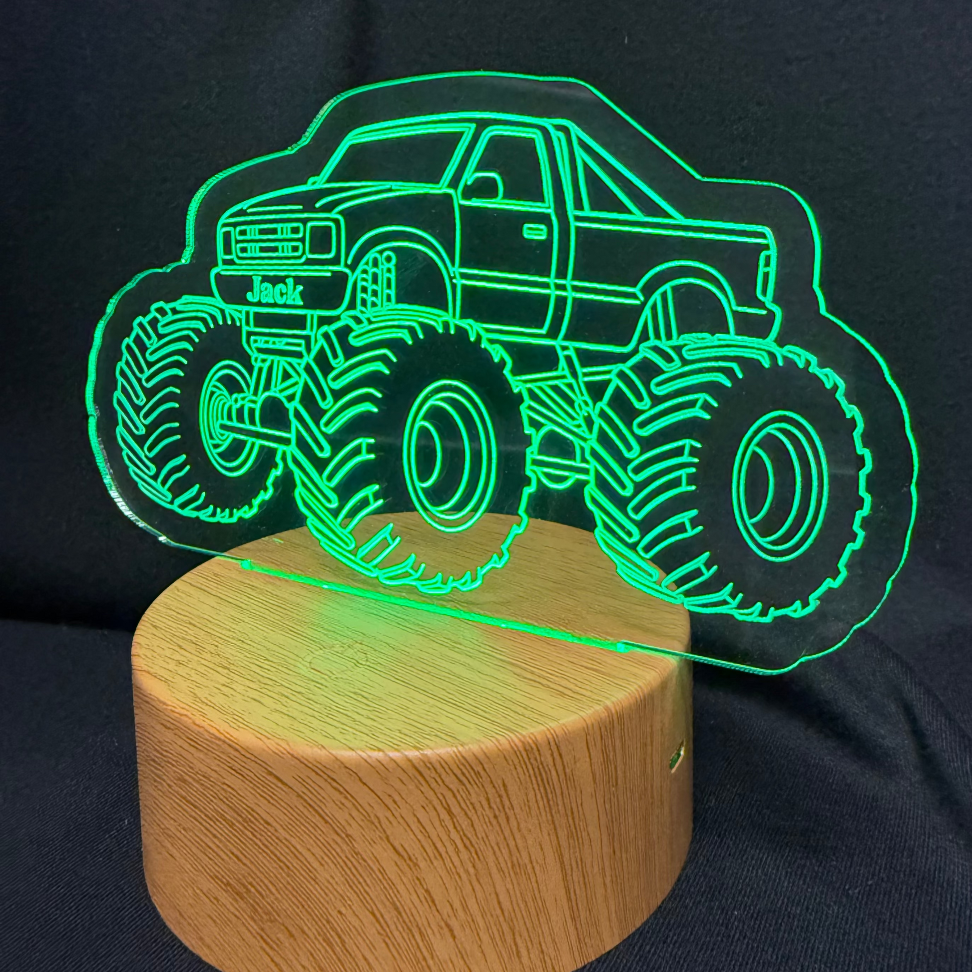 Monster truck design night light on a wooden base against a black background