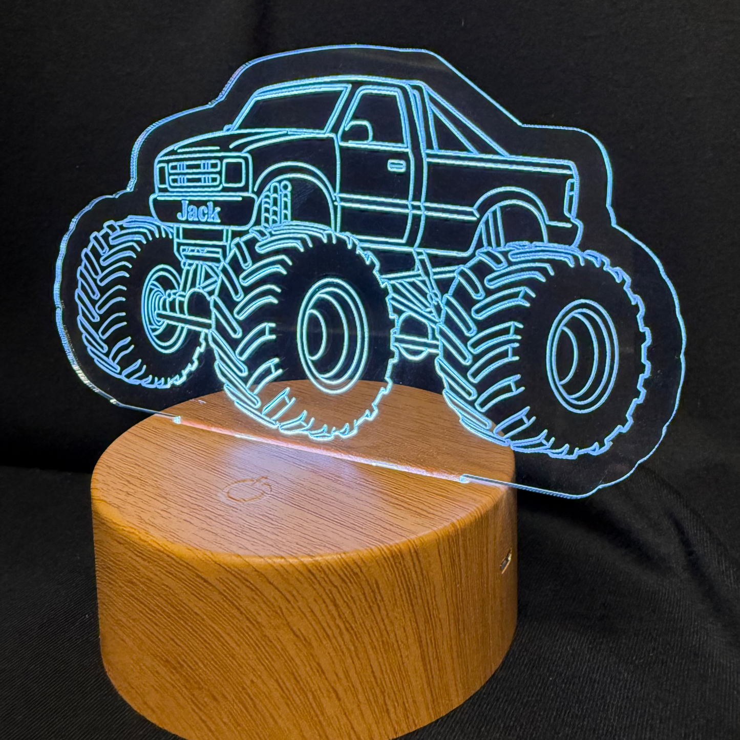 Monster truck design on a wooden base with a black background