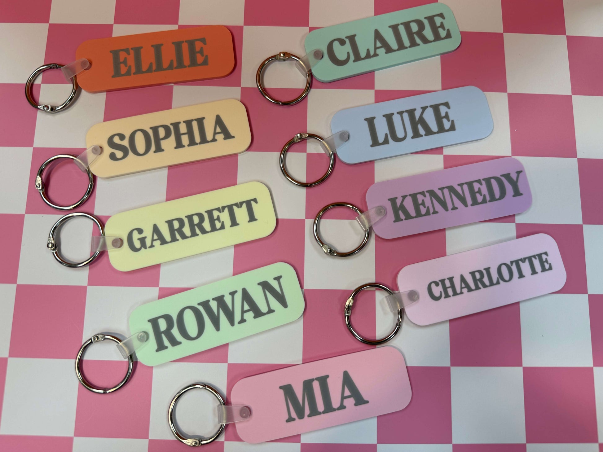 Set of personalized keychains with names on a checkered background