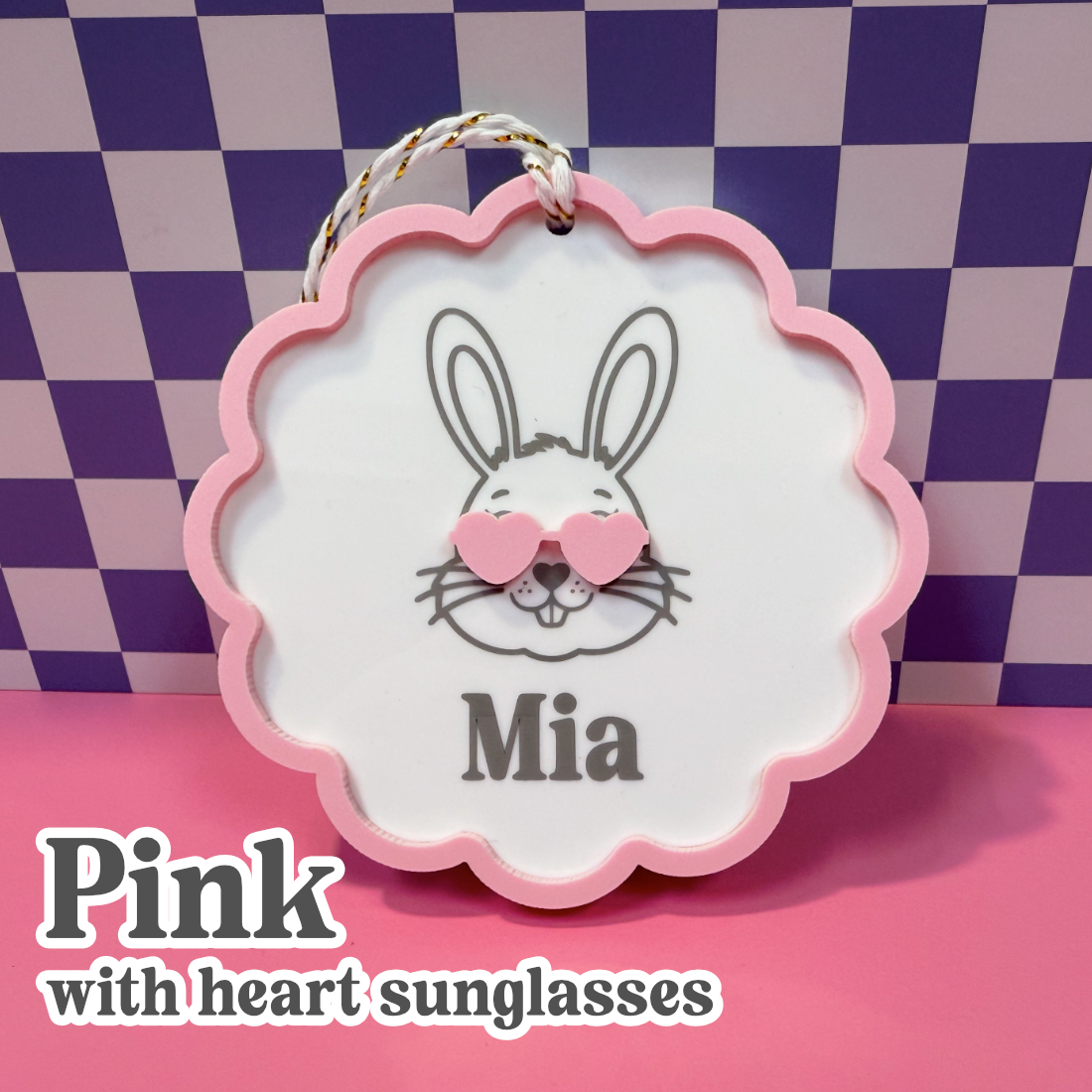 Decorative sign with a rabbit design wearing heart sunglasses and the name 'Mia' on a checkered background.