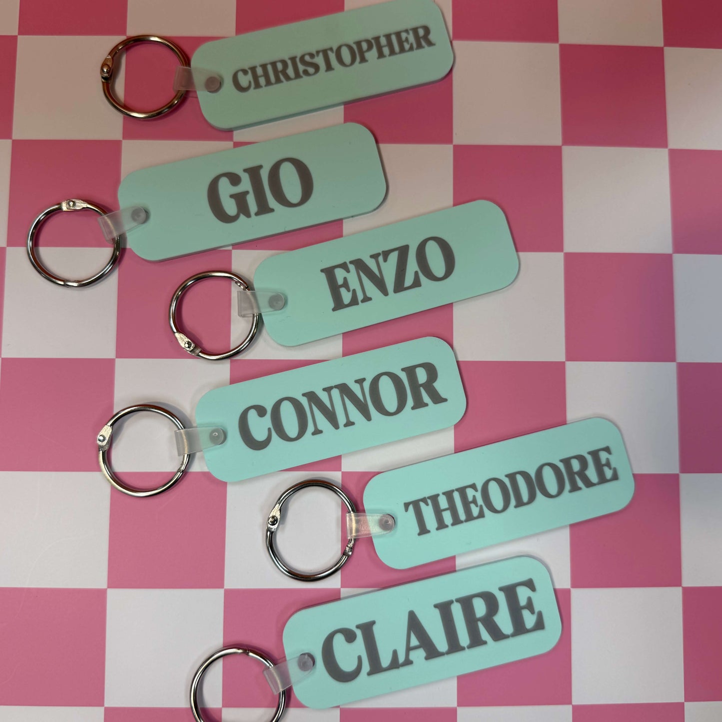 Set of personalized name tags on a pink and white checkered background