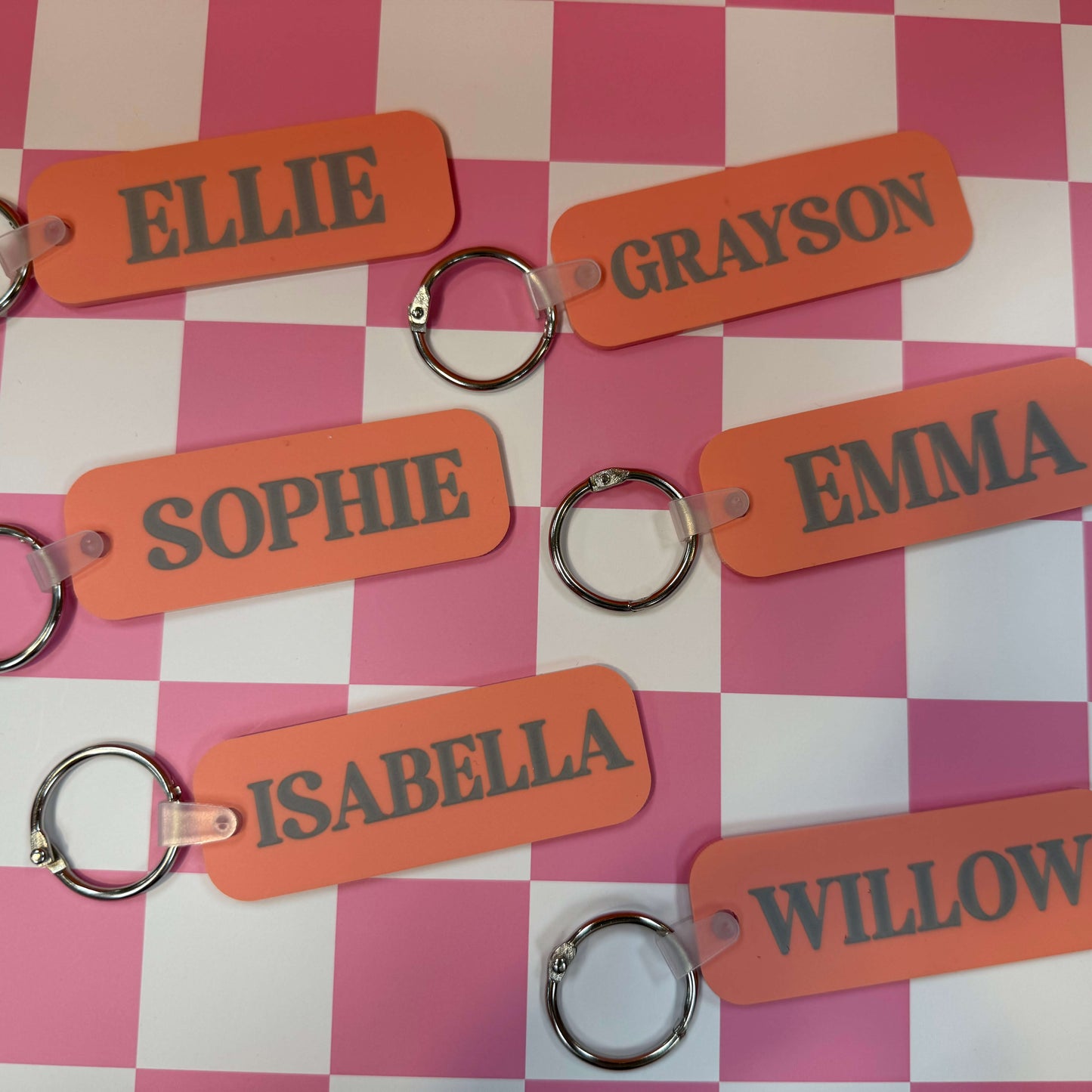 various dark pink bag tags on a checkered background