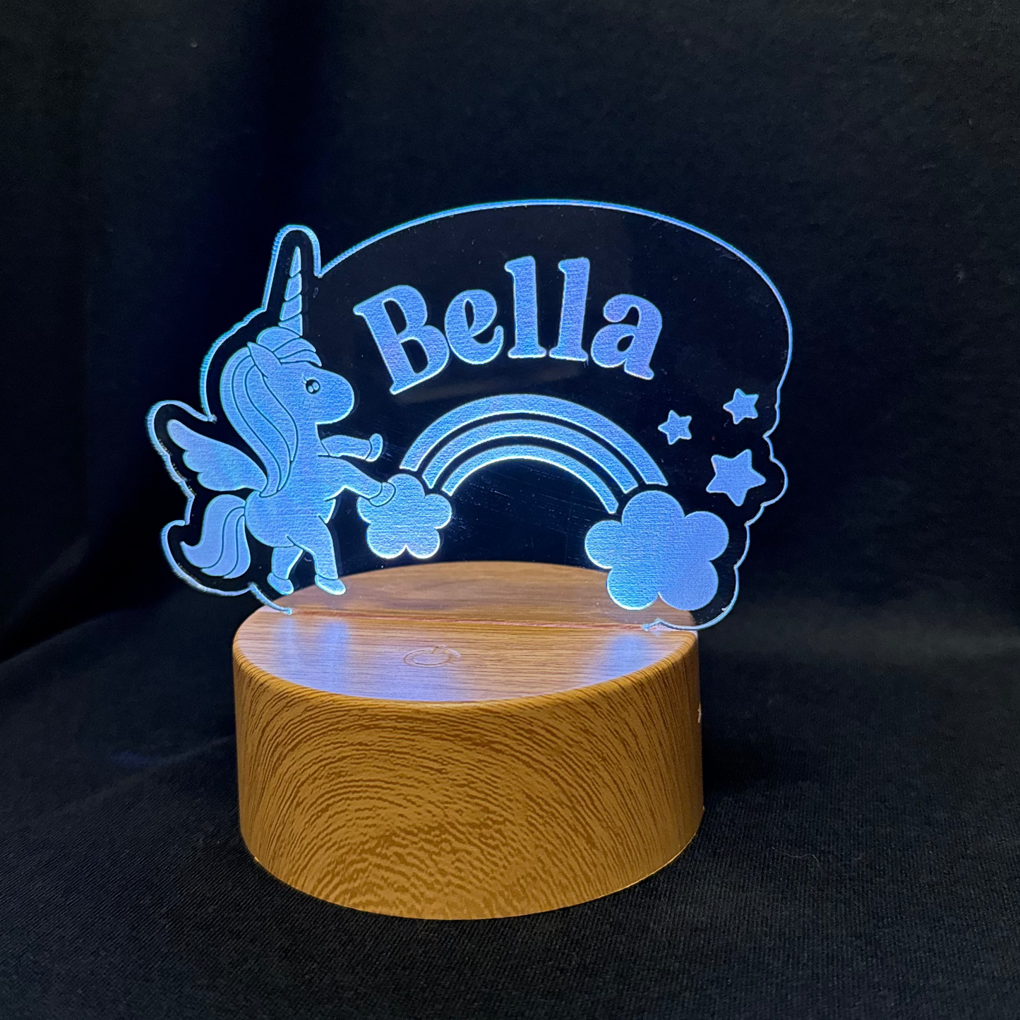 Decorative night light with 'Bella' and unicorn design on a dark background