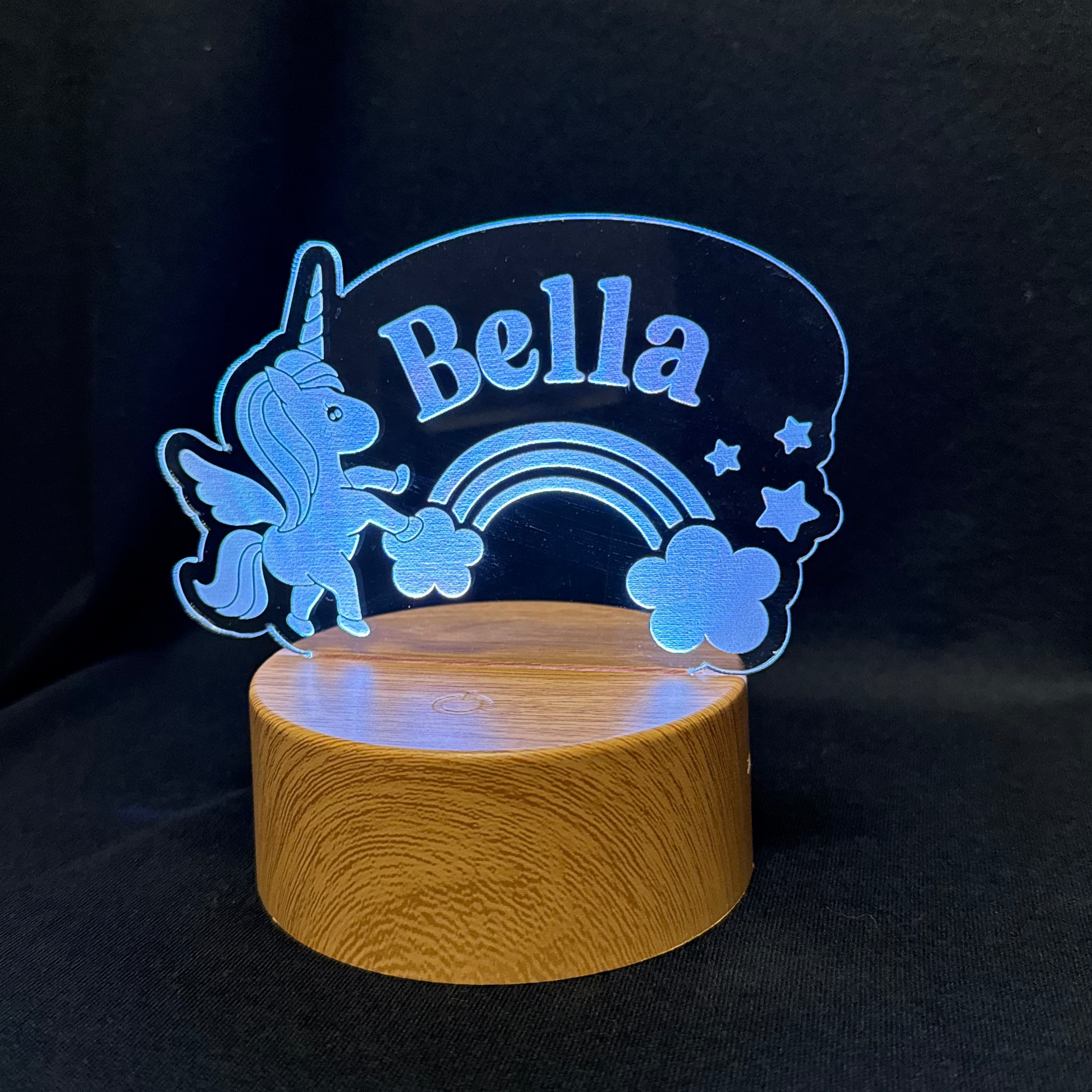 Decorative night light with 'Bella' and unicorn design on a dark background